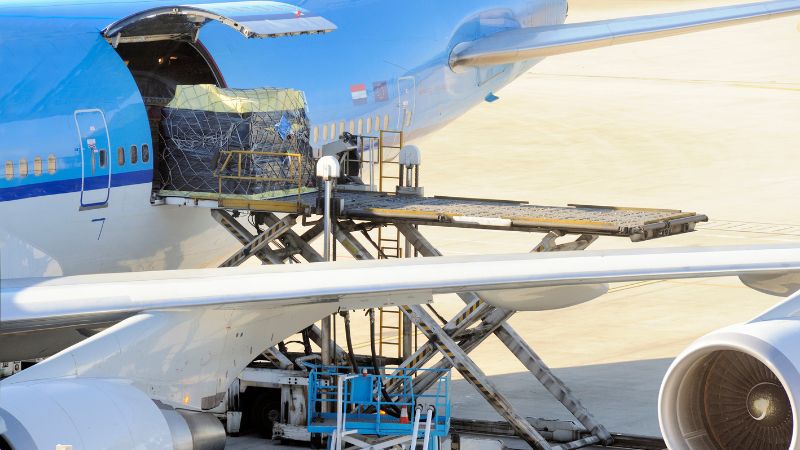 Air freight pallet being loaded into the cargo hold of an airplane