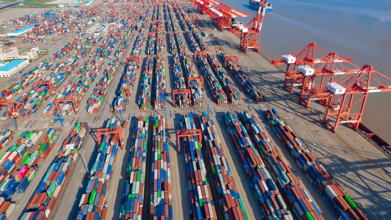 Shanghai Yangshan Deep Water Container port with shipping containers and cranes for cargo handling at the dockyard for logistics and transportation.